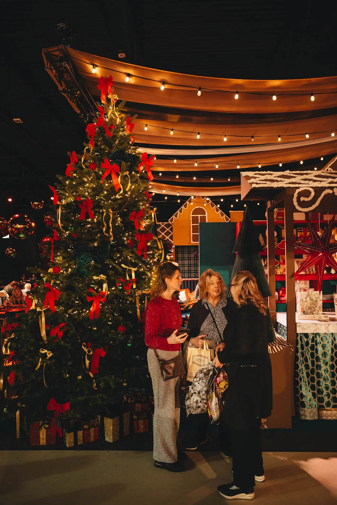 Bezoekers shoppen bij een kerstboom in wintersfeer